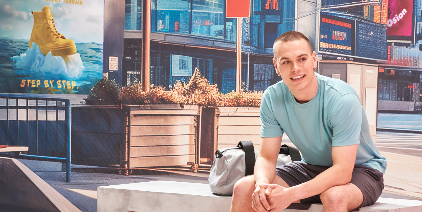 Moški model sedi na klopi